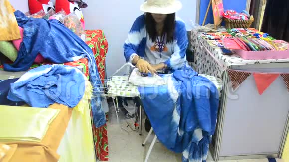 泰国妇女用熨斗烫衣服出售视频的预览图