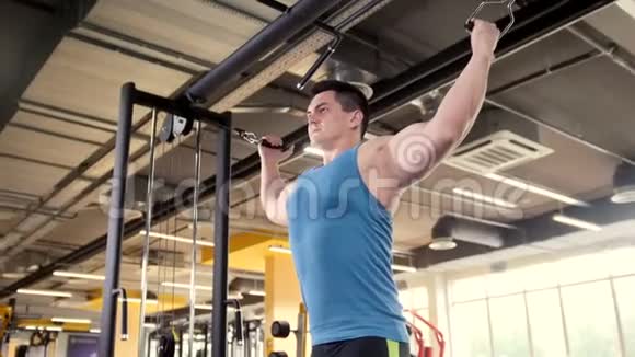 健身馆里的健美运动青年男子进行手臂训练视频的预览图