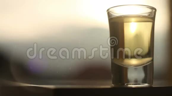 一杯酒精饮料在太阳和山的背景下随着大雪而醉视频的预览图