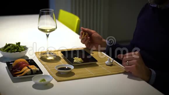 有胡子的人在晚餐时吃寿司喝白葡萄酒视频的预览图