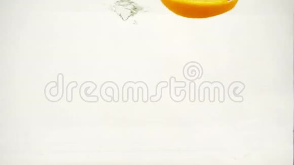 橙色切片落入水中溅出气泡慢动作特写视频的预览图