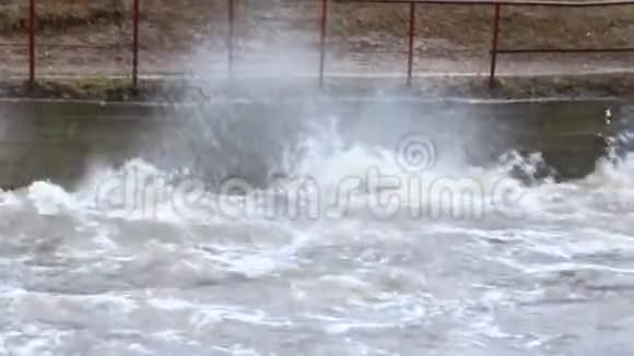 春季洪水期间水在大坝上肆虐融雪期间的洪水视频的预览图