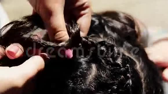 女人在海滩上编织辫子发型夏日阳光明媚无忧无虑视频的预览图