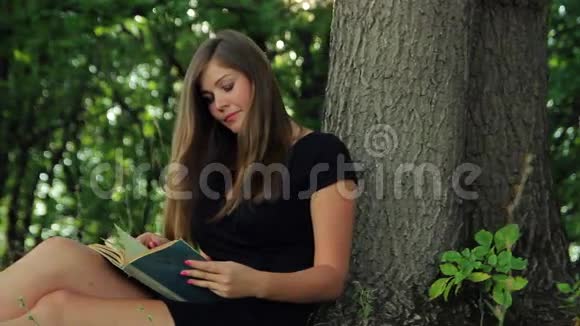 穿着裙子的漂亮女孩坐在公园里视频的预览图