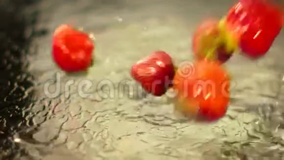 潮湿的草莓溅落在水面上视频的预览图
