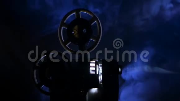 电影放映机在烟雾弥漫的黑暗演播室里放映电影投影射线视频的预览图