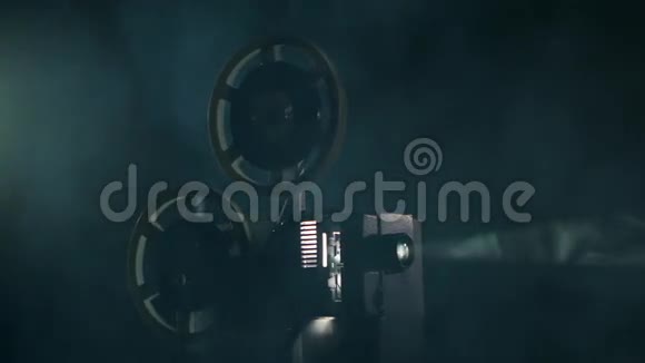老式投影仪在烟雾弥漫的黑暗工作室里放映电影投影射线视频的预览图