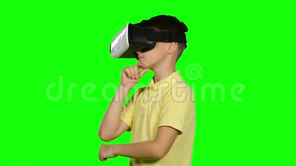男孩使用虚拟现实耳机头盔绿色屏幕视频的预览图