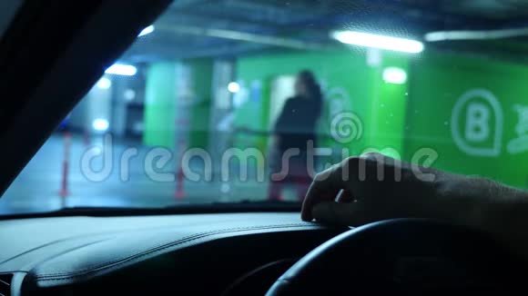 一只人的手在汽车仪表板上特写而在超市的一个封闭停车场里等待4k慢动作视频的预览图