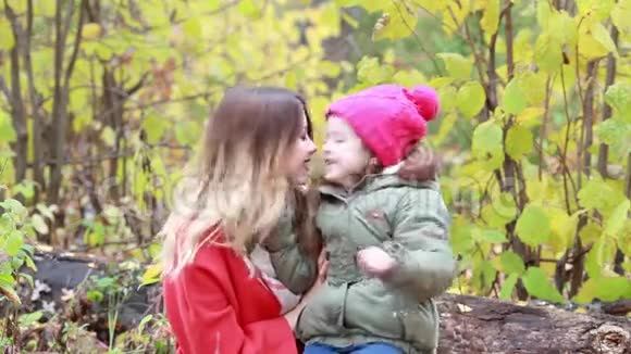 妈妈和女儿在秋天的森林里散步视频的预览图