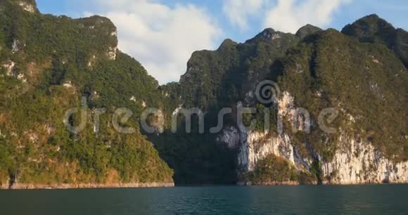 日落时乘船游热带湖水高山悬崖和岩石视频的预览图