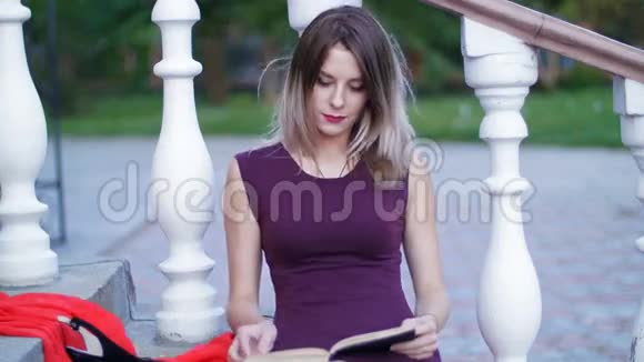 坐在楼梯上看书的漂亮女孩视频的预览图