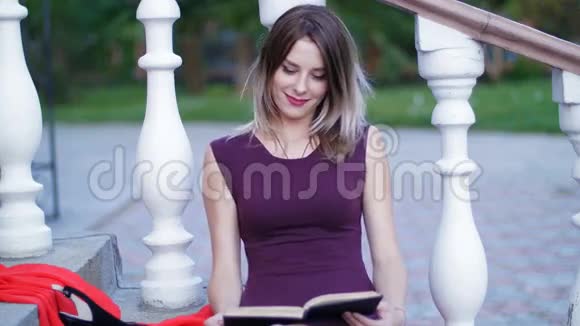 坐在楼梯上看书的漂亮女孩视频的预览图