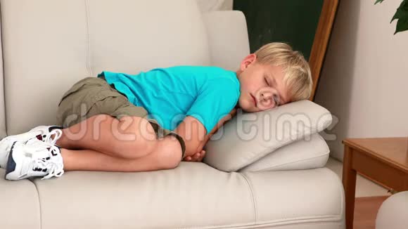 可怜的小男孩躺在沙发上视频的预览图