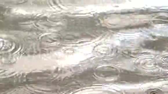 雨水落在水位上形成许多水滴圈小波浪掠过水面在许多阴影中移动视频的预览图