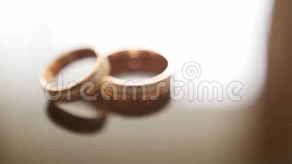 镜框眼镜桌上的金色结婚戒指一个在另一个上面视频的预览图
