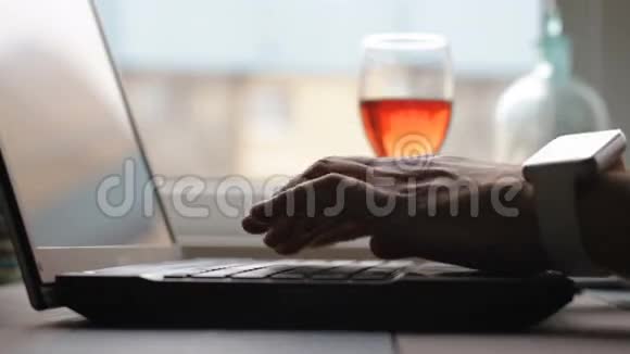 这名男子让商务办公室在笔记本电脑键盘高清视频的暗键上缓慢打印视频的预览图