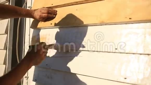 人在街上用白色油漆刷一道油漆刷一道木墙视频的预览图