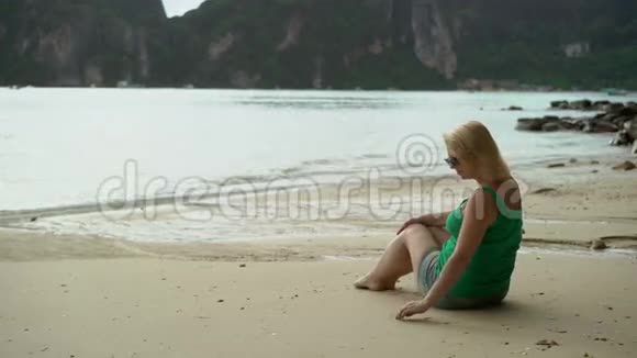一个女人独自坐在海滩上视频的预览图