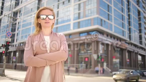戴墨镜的女人站在繁忙的街道上女人城市的居民视频的预览图