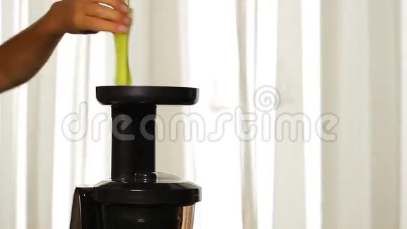 女人的手在榨汁机里加入芹菜视频的预览图