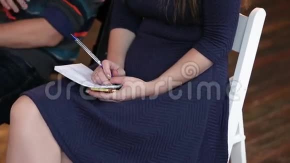 女人在讲座上写在笔记本上视频的预览图