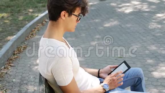 城市公园的年轻人使用电子书阅读器视频的预览图