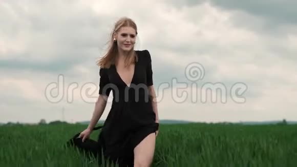 穿着黑色礼服的华丽女郎在田野旁视频的预览图