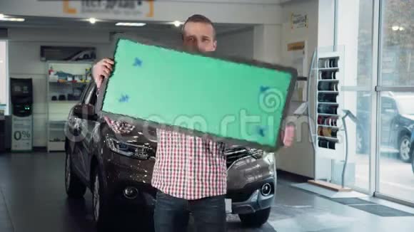 持有绿色标牌的汽车经销商视频的预览图