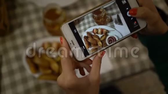 双手紧握智能手机为社交网络拍照食物视频的预览图