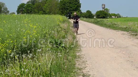 夏天男人沿着乡村道路的边缘奔跑视频的预览图