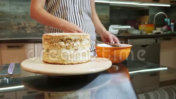 女人用刀子把巧克力奶油放在海绵蛋糕上视频的预览图