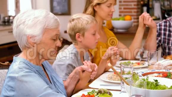 可爱的家人在吃晚饭前祈祷视频的预览图