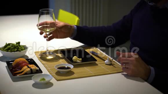 有胡子的人在晚餐时吃寿司喝白葡萄酒视频的预览图