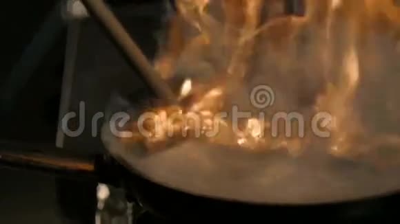 厨师烹饪与火在煎锅n专业厨师在商业厨房烹饪火焰风格烹饪牛肉视频的预览图