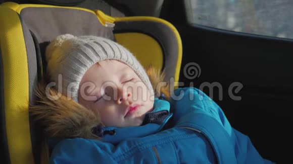 幼儿男孩在汽车上睡在儿童安全座椅上视频的预览图