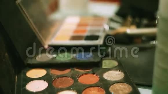 化妆设计师把刷子放在五颜六色明亮的眼影里化妆品美丽妇女镜镜视频的预览图