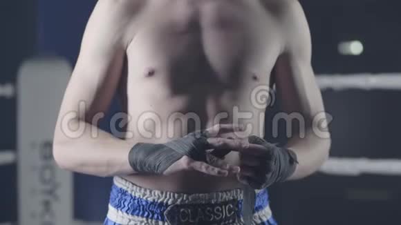 一名混合武术拳手的特写在一场战斗前包住了他的手拳击手用红色绷带包扎他的手视频的预览图