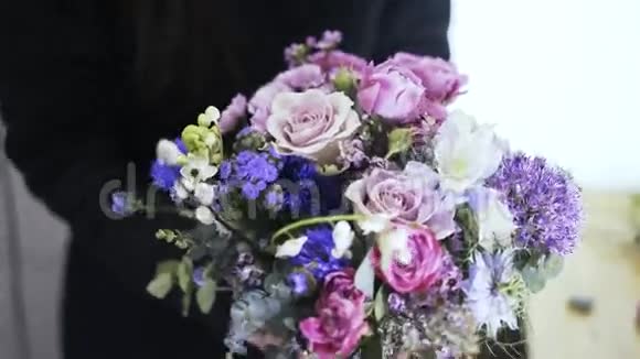 一位持有一束美丽花朵的女花店前景视频的预览图