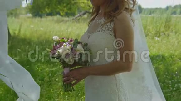 在户外草地新娘捧着婚礼花束视频的预览图