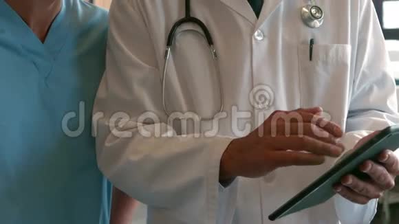 一位严肃的医生在拿着药片的时候和男护士说话视频的预览图