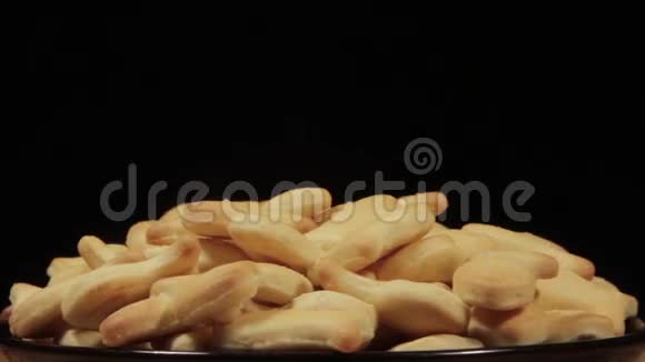 饼干饼干在黑色背景的黑色盘子上旋转视频的预览图