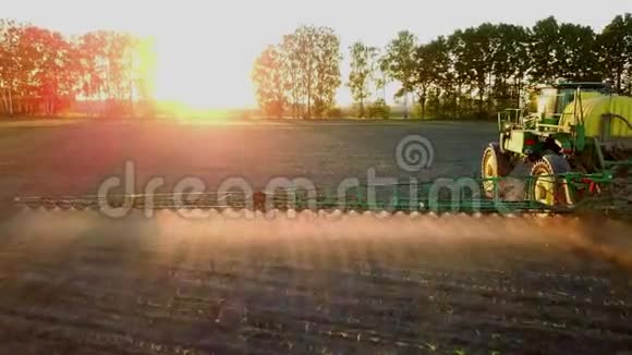 拖拉机在日落时在田野里喷洒化学物质视频的预览图