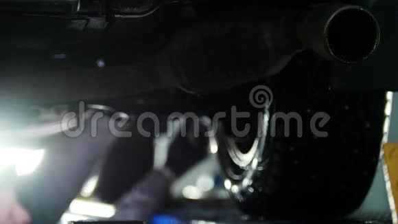 汽车诊断机械师在提升的汽车下工作去聚焦的背景视频的预览图