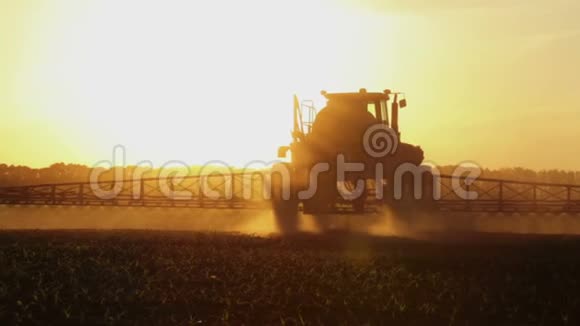 拖拉机在日落时在田野里喷洒化学物质视频的预览图