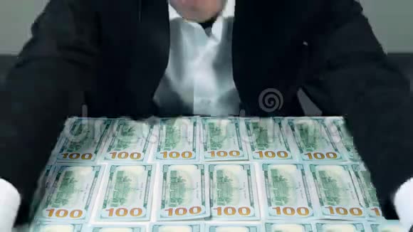 贪婪的认不出来的商人手里抓着许多一百美元的钞票视频的预览图