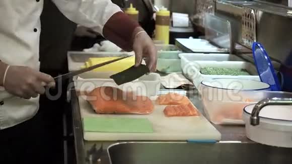寿司卷三文鱼的制作和切割过程用刀子把鱼切成薄片视频的预览图