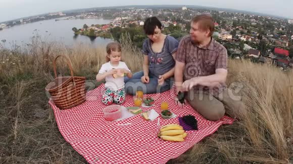 一家三口人爸爸妈妈和一个孩子在周末野餐视频的预览图
