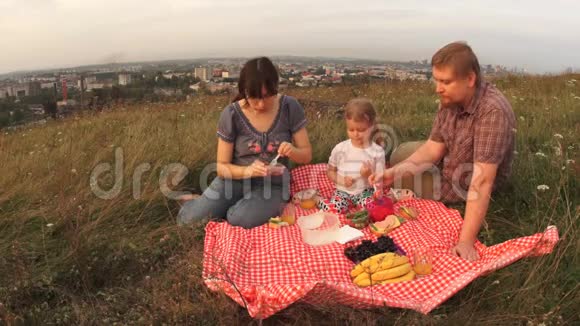 一家三口人爸爸妈妈和一个孩子在周末野餐视频的预览图