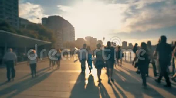 令人惊叹的金色光城堤日落与步行放松的人城市建筑和海浪在美丽的l视频的预览图